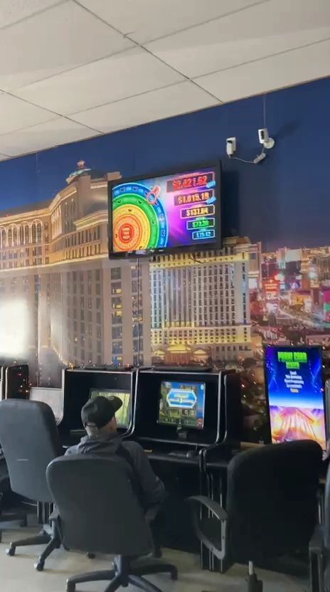 Rows of sweepstakes gaming machines with neon murals inside Northeast TelConnect Sweepstakes — best casino-style entertainment near El Paso TX 79924